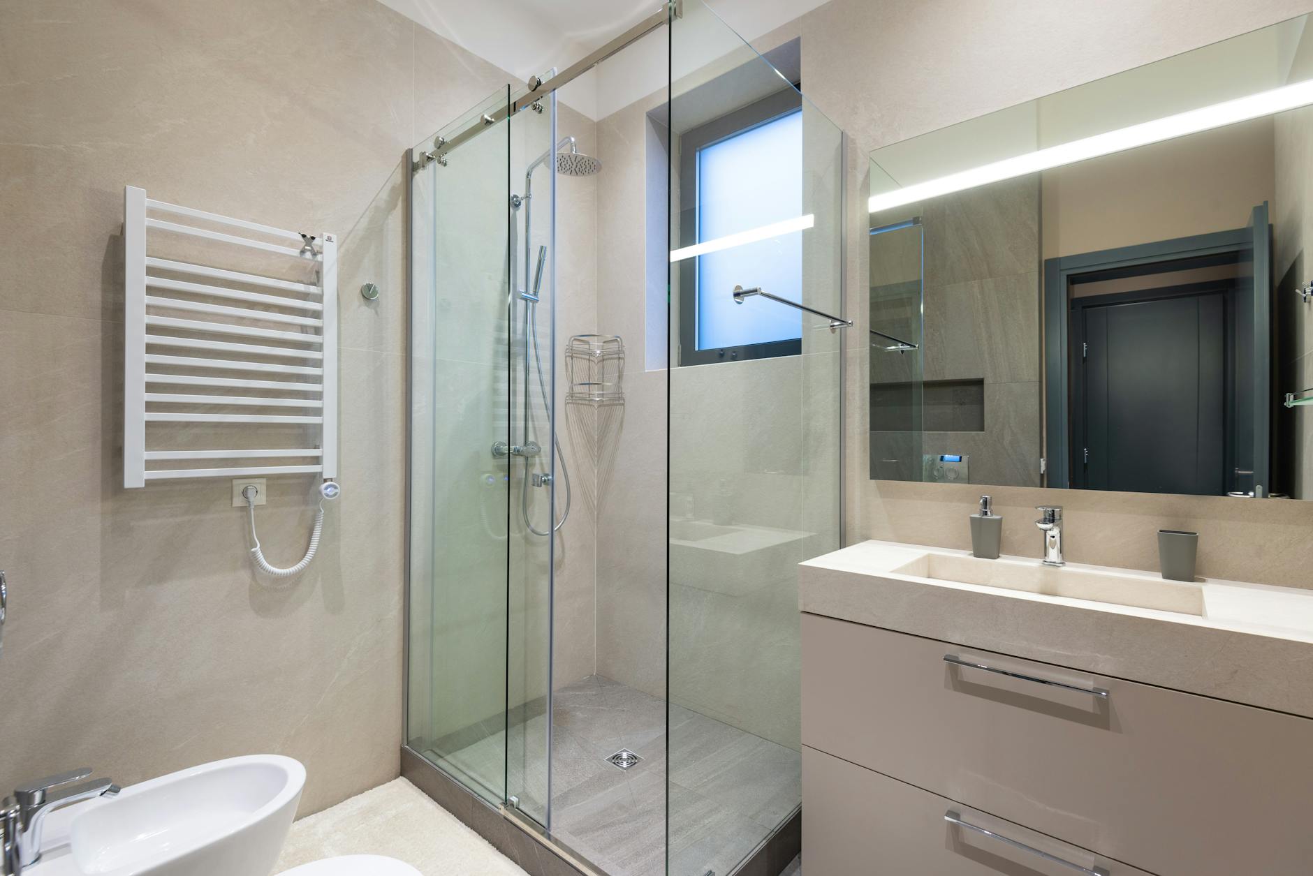 Minimalist bathroom with glass shower and clean stone surfaces